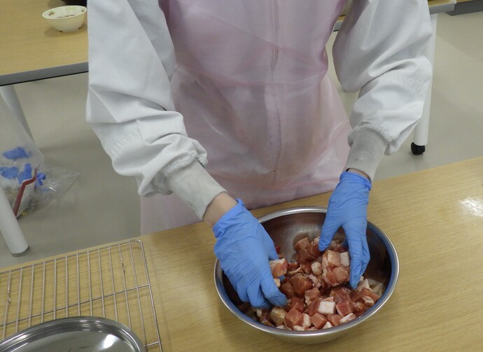 二次審査:給食調理写真（豚肉に下味をつけているところ）